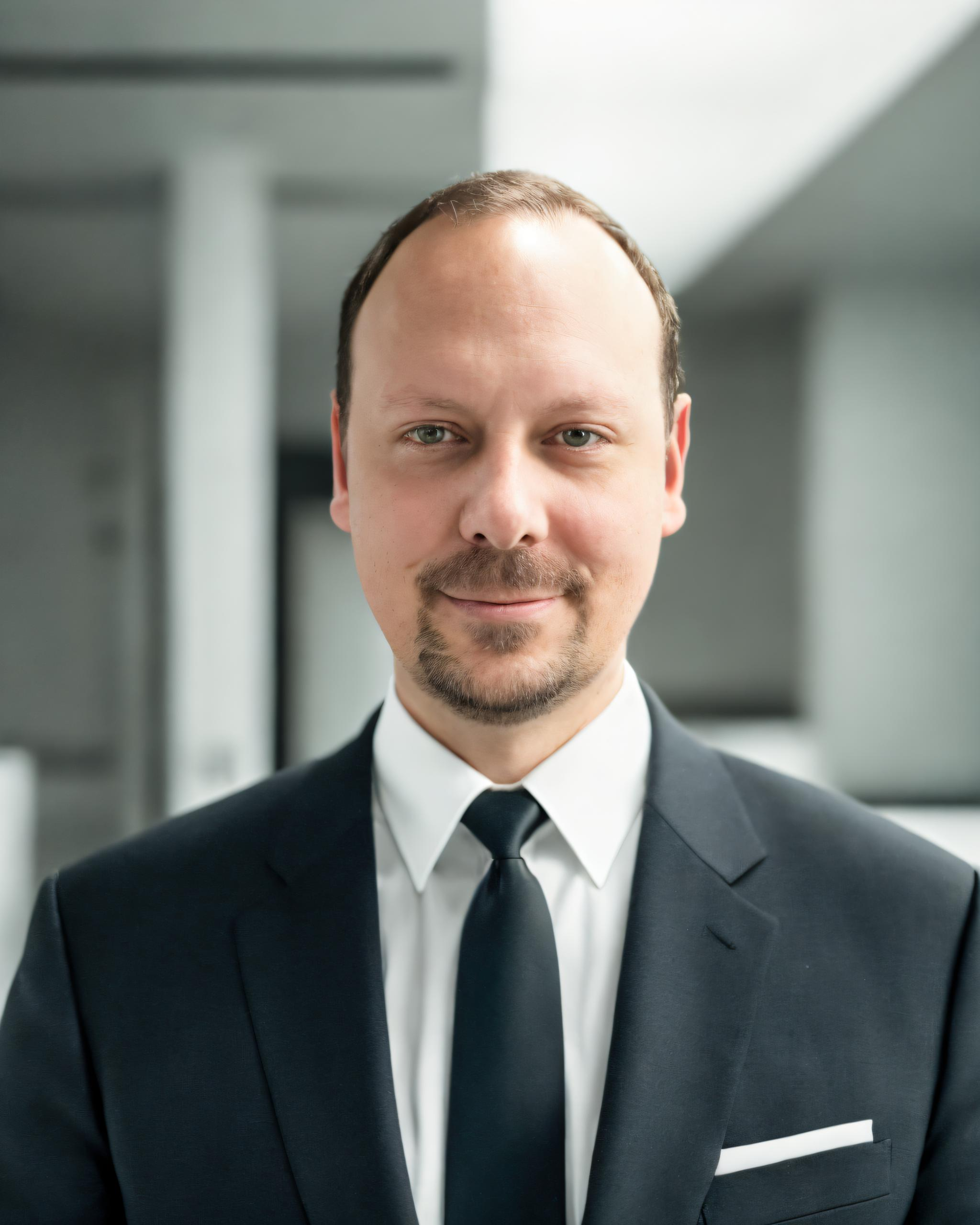Portraitfoto vom SAC Produktvertriebsmitarbeiter Alexander Butter lächelnd im Anzug